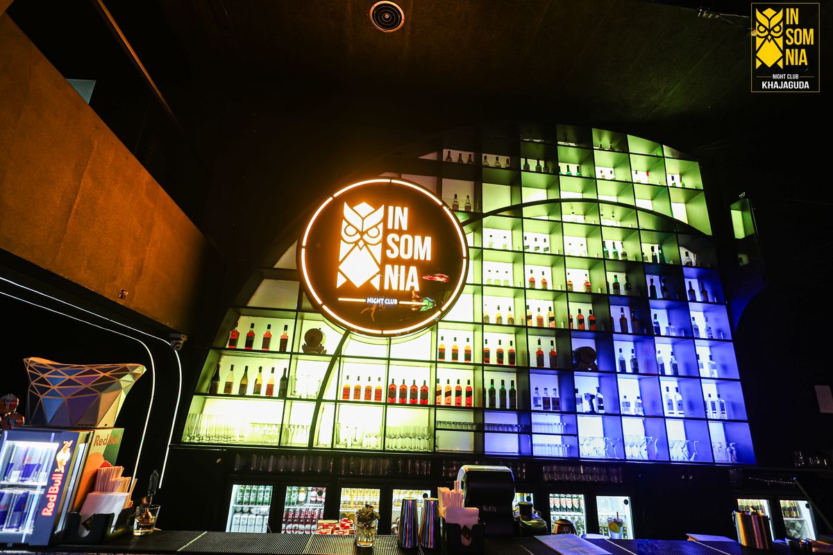 Backlit bottle wall beneath the neon logo — Insomnia Night Club, Khajaguda, Hyderabad